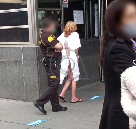 La mujer con la bata blanca de hospital y junto a ella un agente de seguridad del Palacio de Justicia/TA.